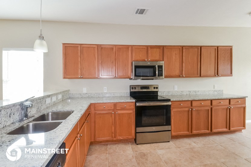 a kitchen with wooden cabinets and stainless steel appliances