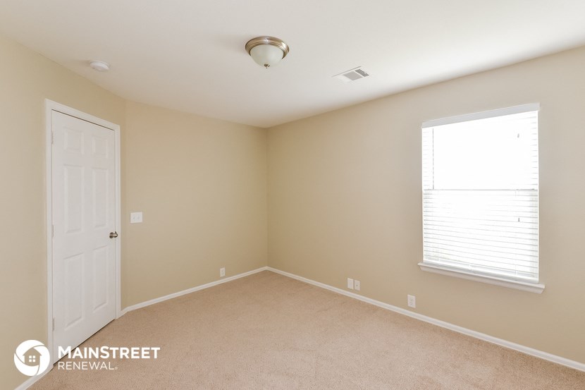 a bedroom with a large window and a white door