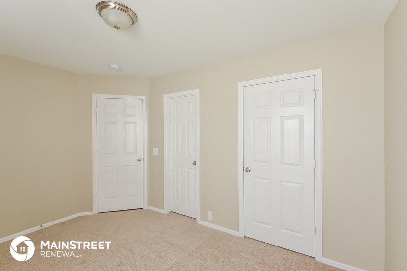 a bedroom with two white doors and a carpeted floor