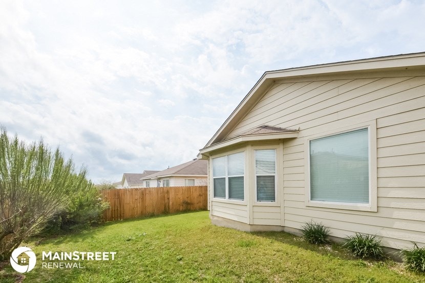 the exterior of a house with a yard and a fence
