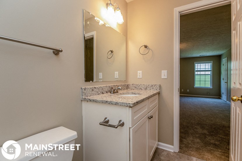 a bathroom with a sink and a toilet and a mirror