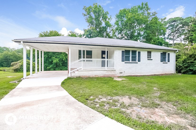 a small white house with a porch and a sidewalk