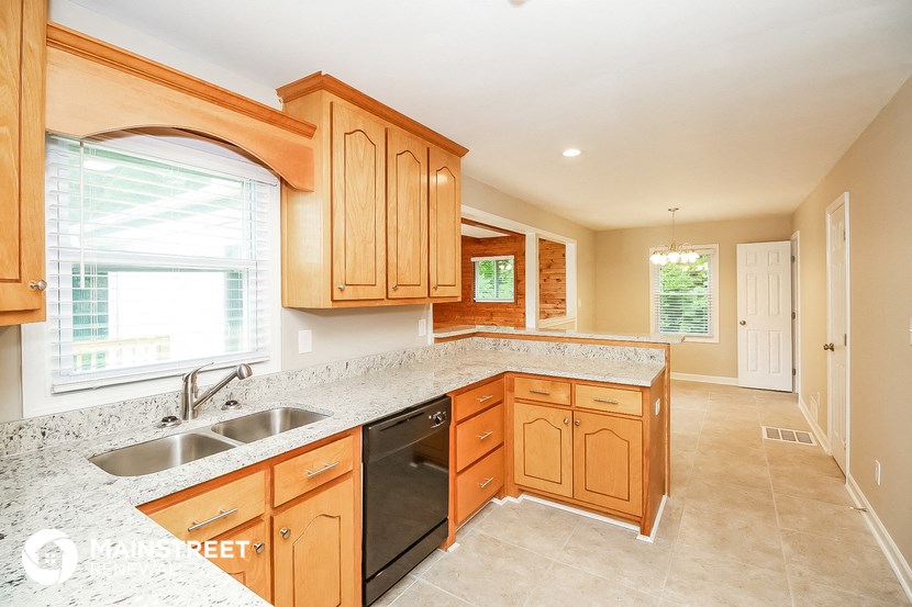 a kitchen with wooden cabinets and granite counter tops and a sink