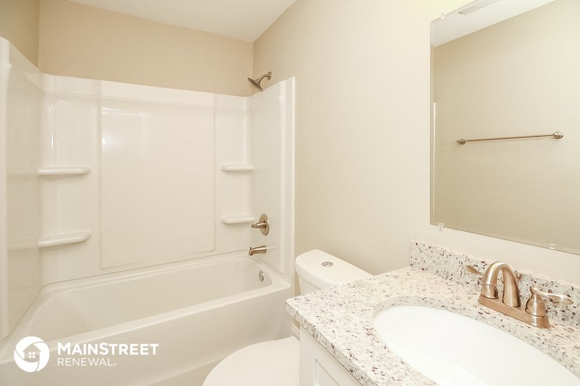 a bathroom with a toilet sink and a tub and a mirror