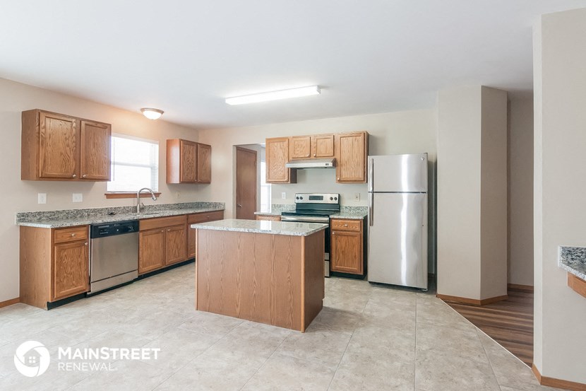a kitchen with wooden cabinets and stainless steel appliances