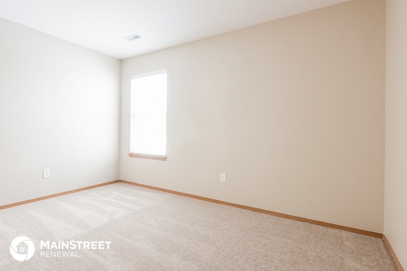 a room with a carpeted floor and a window