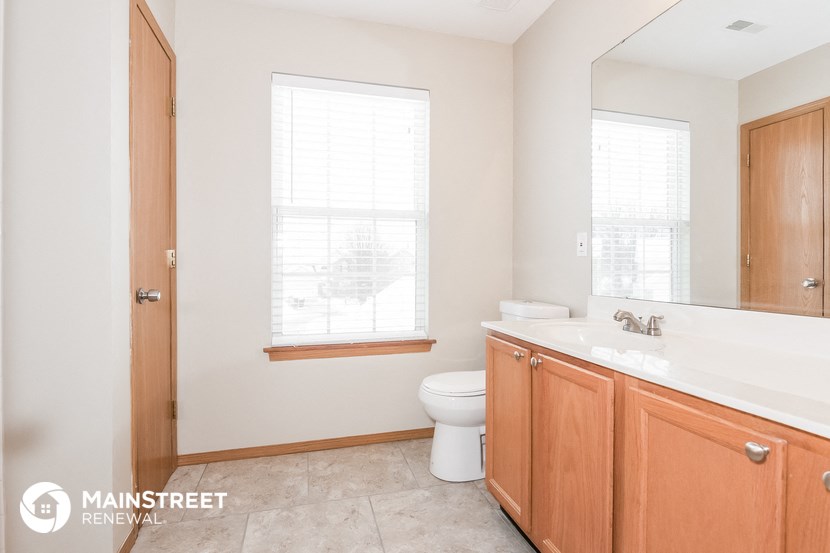 a bathroom with a toilet and a sink and a mirror