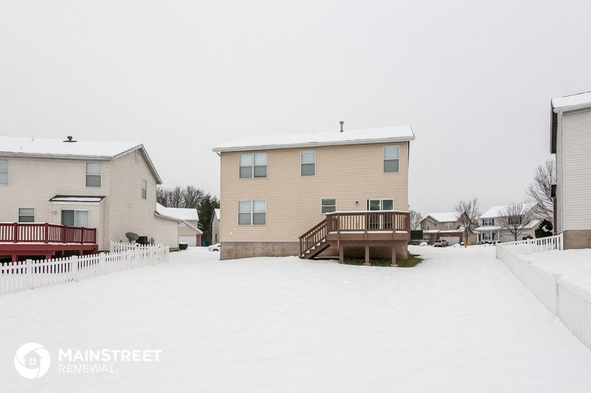 a home with a deck in the snow