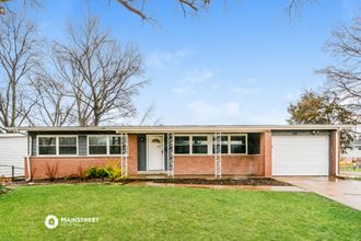 a small brick house with a lawn in front of it