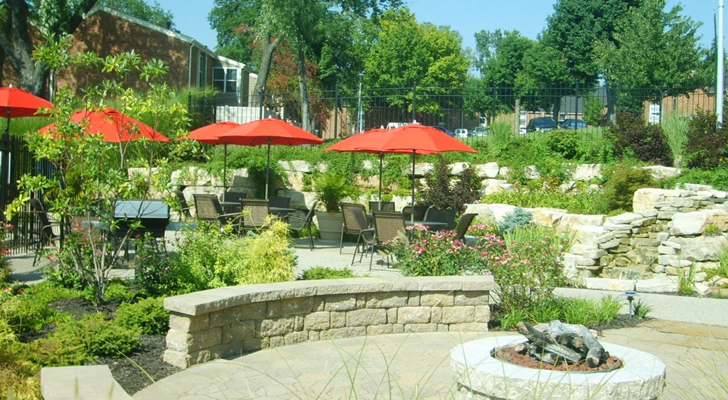 a patio with tables and umbrellas and a fire pit