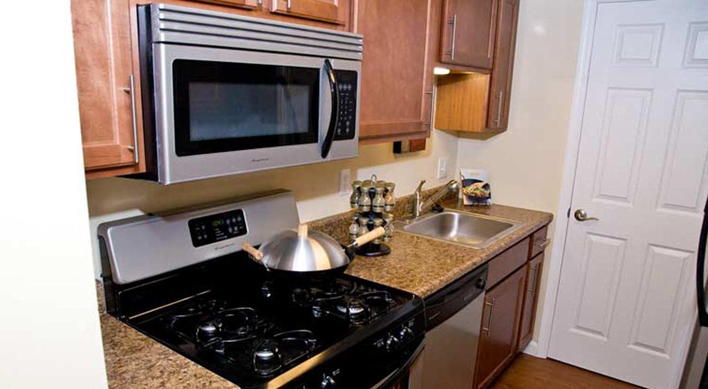 a kitchen with a stove and a microwave and a sink