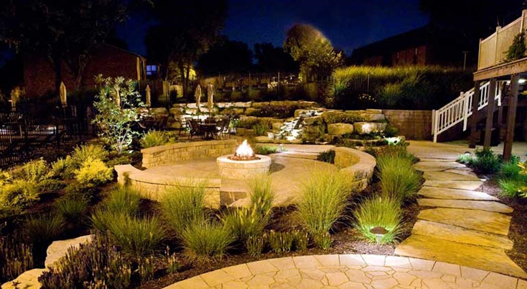 a backyard with a fire pit at night