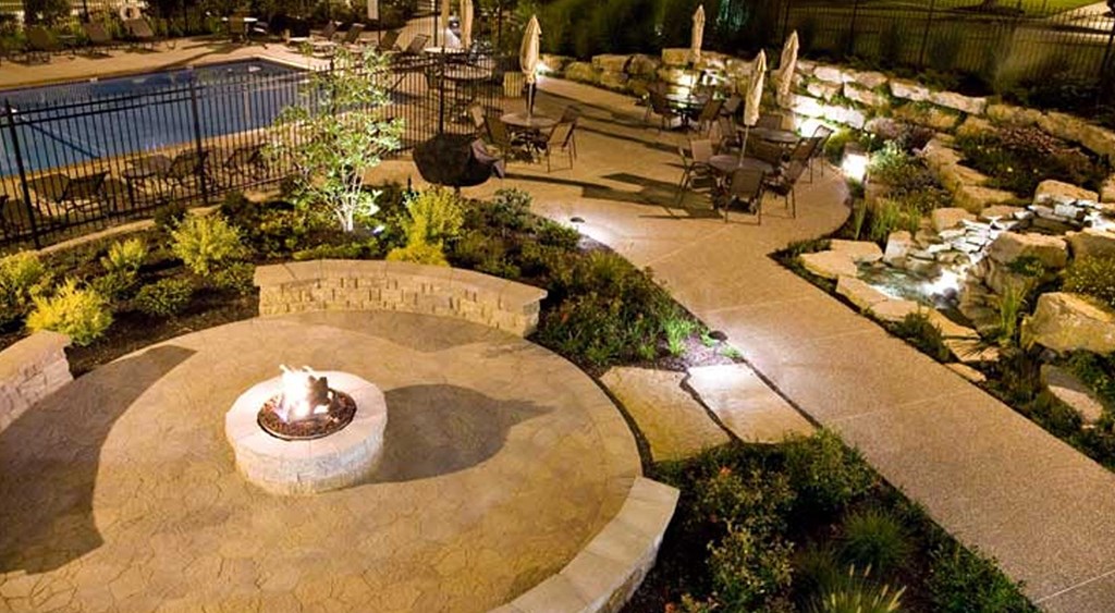 a fire pit is in the middle of a garden at night