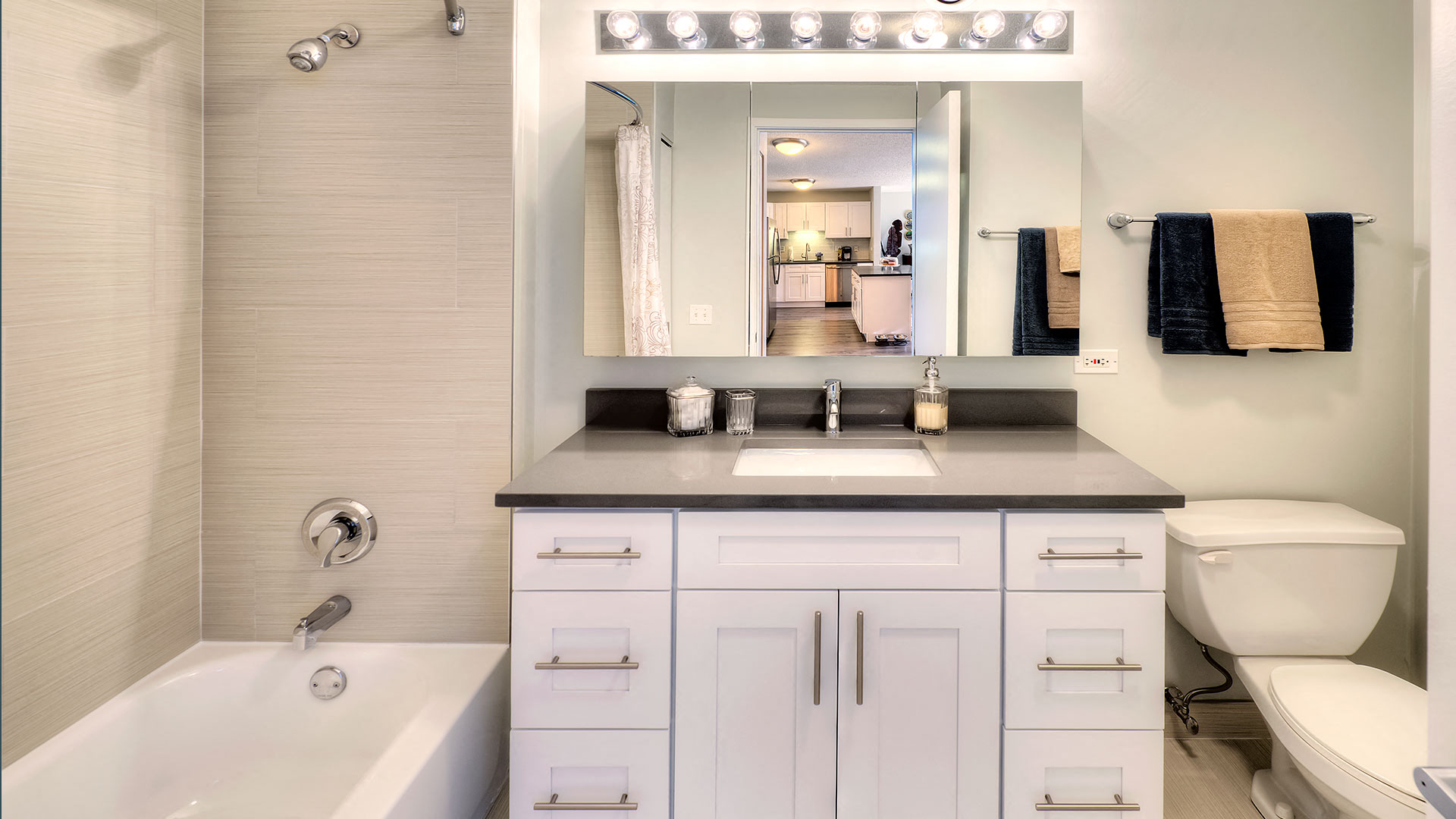 Looking at a bathroom vanity straight on. To the left is the shower and tub and to the right is the toilet.