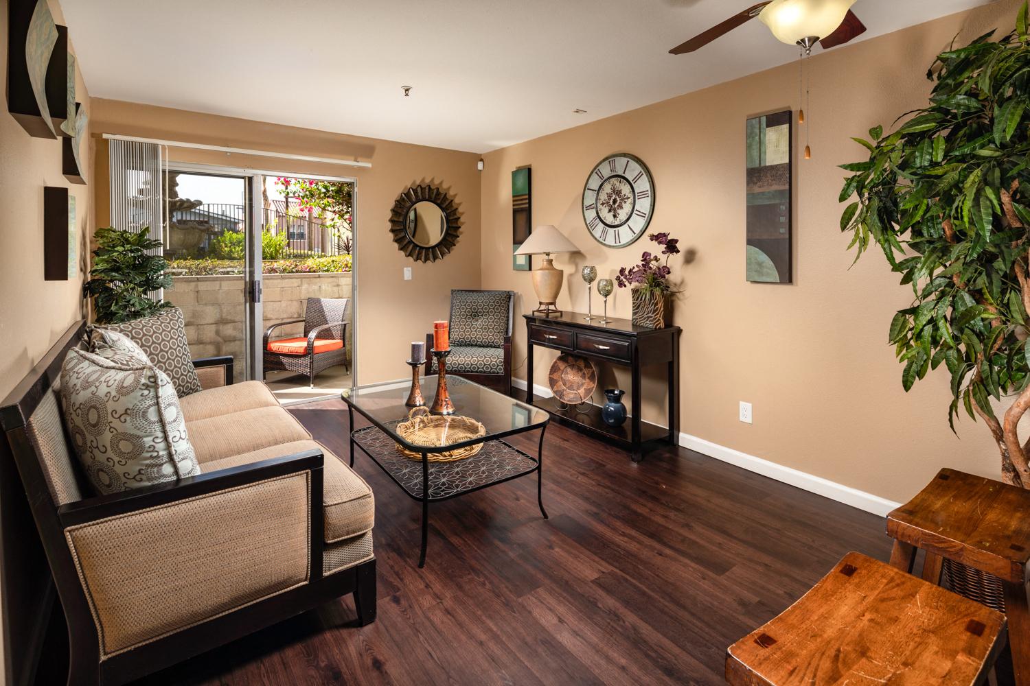A living room with a couch, coffee table, and a plant.