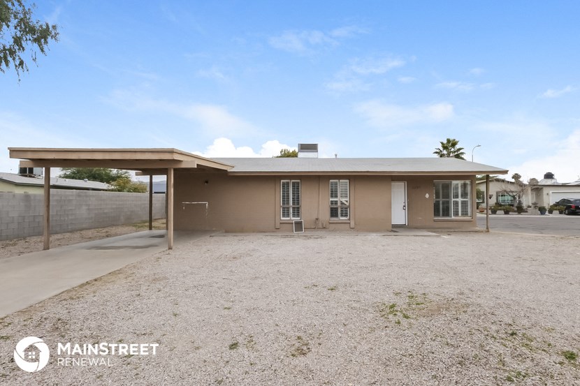 a small house with a dirt yard and a covered porch