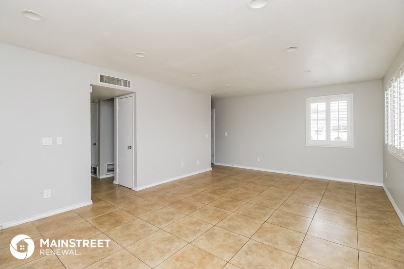 the spacious living room with tile flooring and white walls