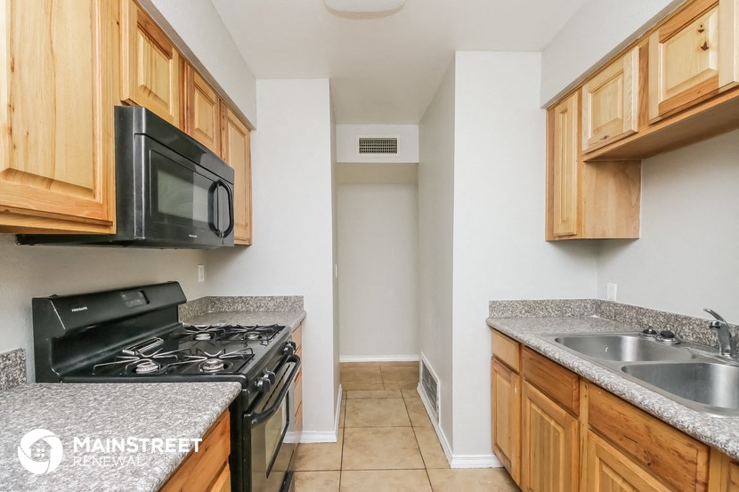 a kitchen with wood cabinets and granite counter tops and a black stove and microwave