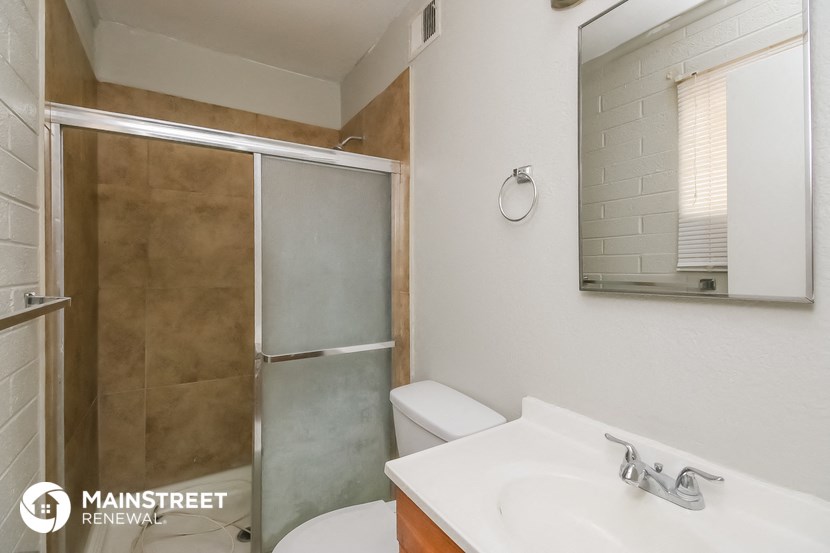 a bathroom with a shower sink and toilet and a mirror