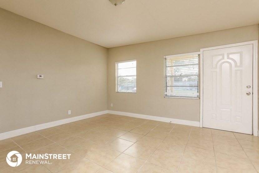an empty room with a white door and a window