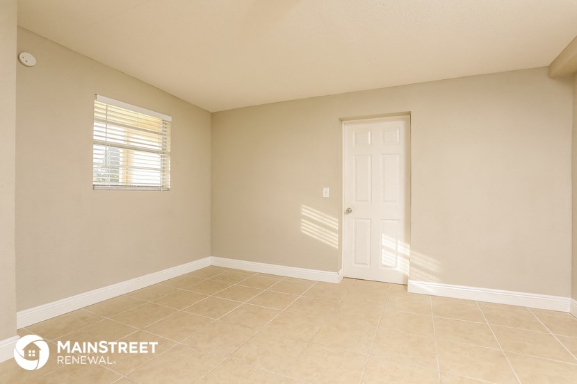 the spacious living room has a tile floor and beige walls