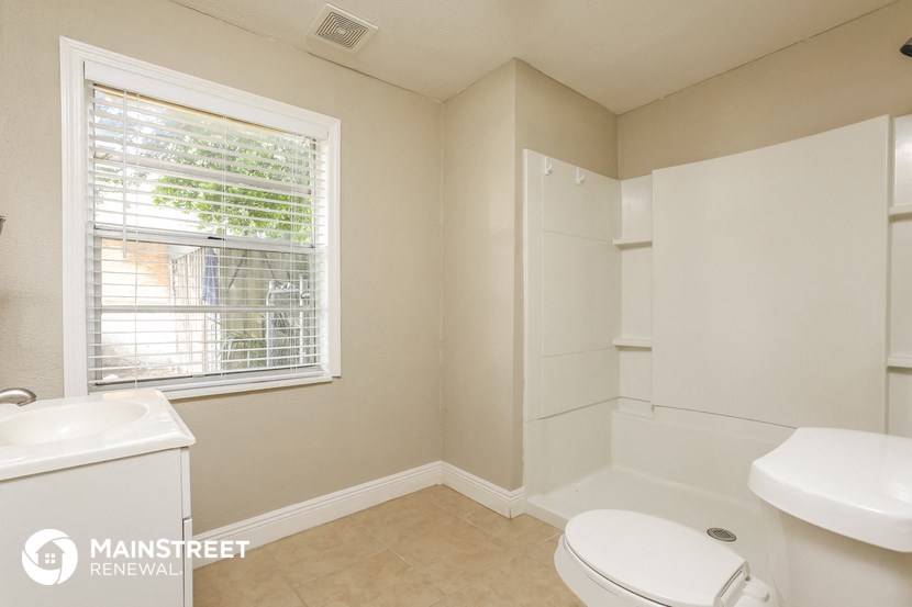 a bathroom with a toilet and a sink and a window