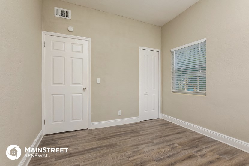 the interior of a bedroom with a door and a window
