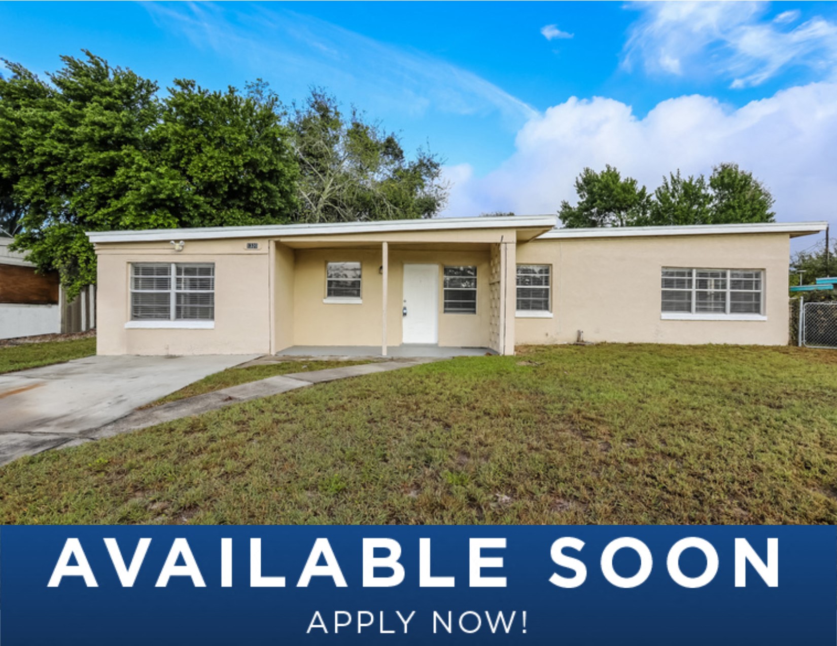 a small beige house with a lawn in front