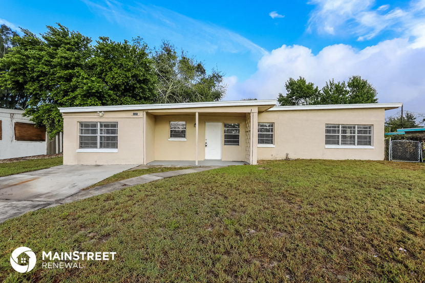 the front of a house with a lawn and a driveway