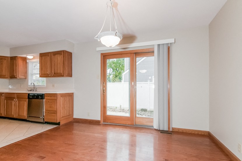 an empty kitchen and living room with sliding glass doors to a patio