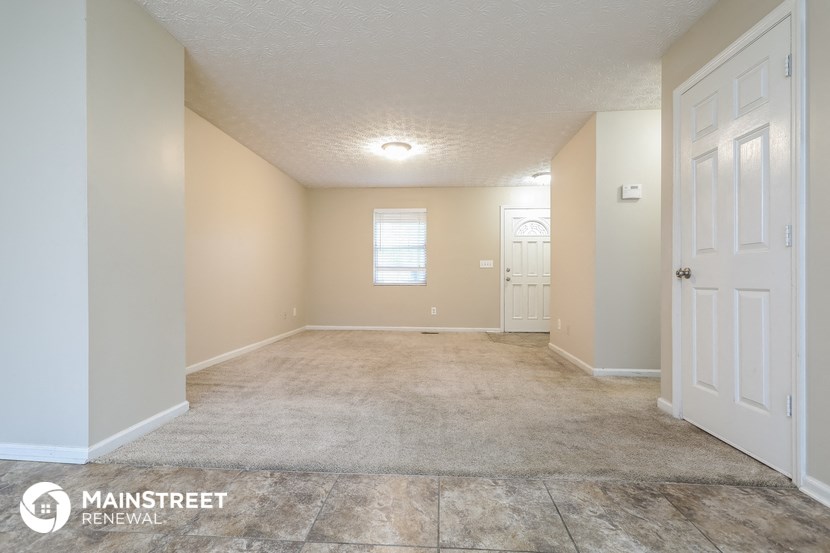 the spacious living room and dining room with white doors