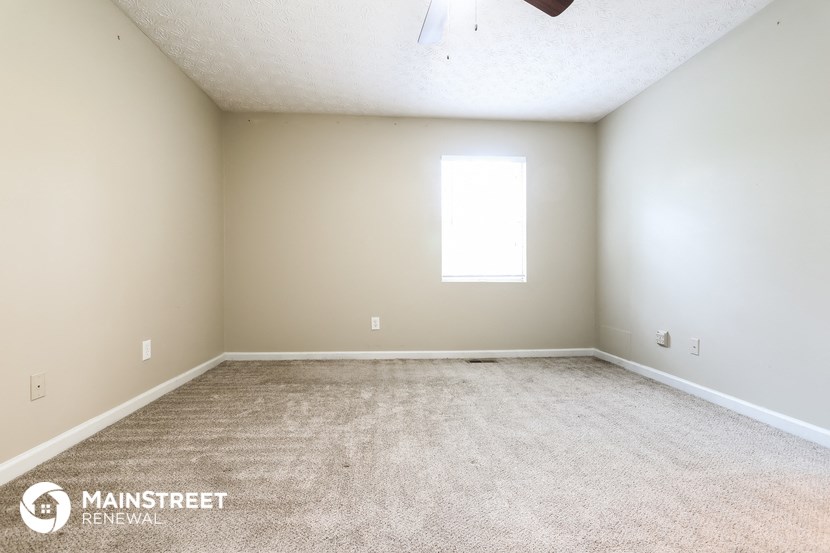 an empty room with carpet and a window
