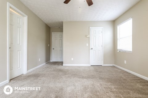 the spacious living room with carpet and white doors