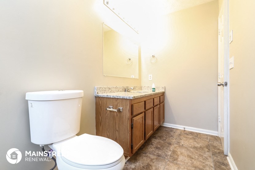 a bathroom with a toilet and a sink and a mirror