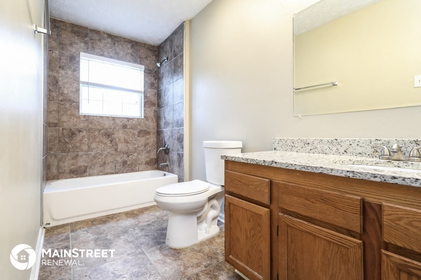 a bathroom with a toilet and a tub and a sink