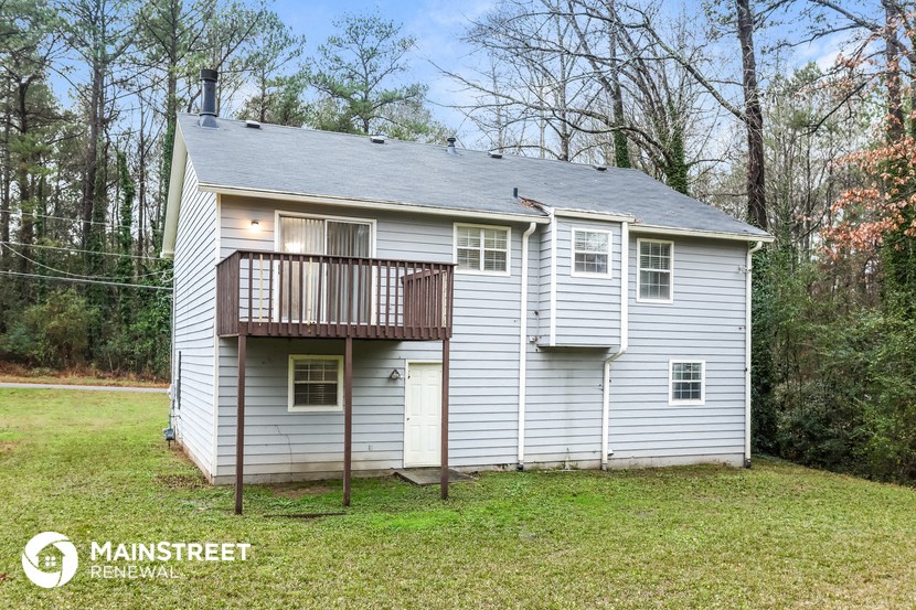 a small white house with a porch and a deck