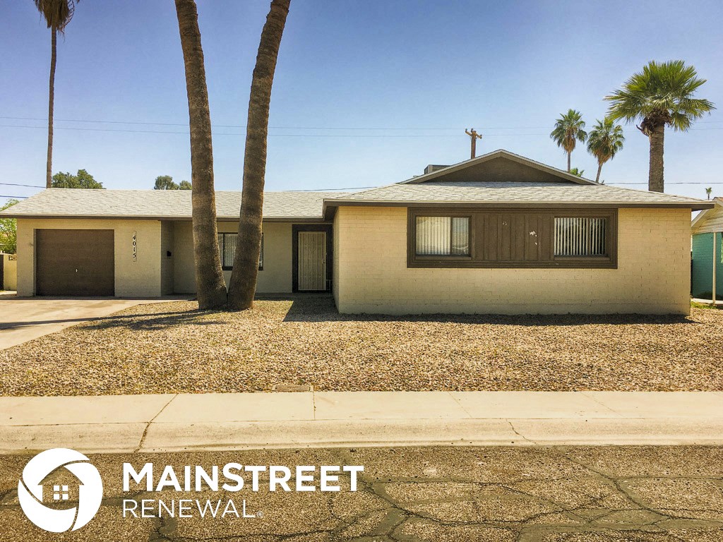 a house with palm trees and a sidewalk