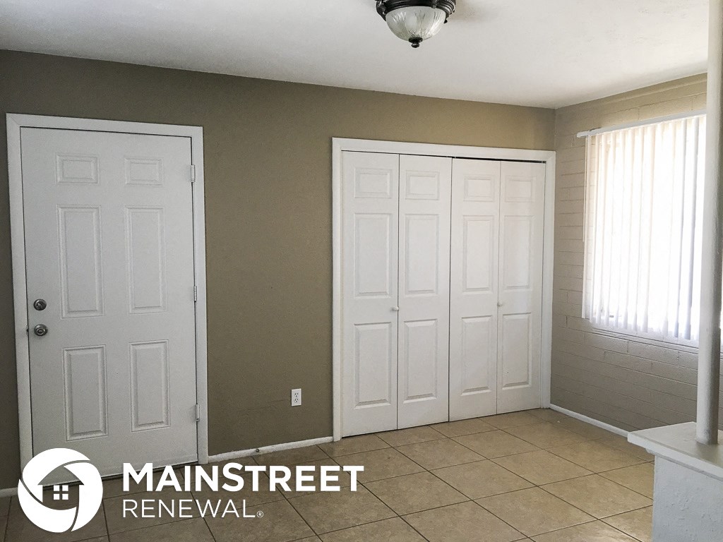 an empty room with two white doors and a tile floor
