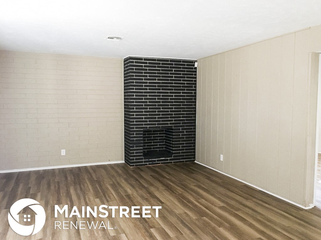 a living room with a fireplace and wooden floors