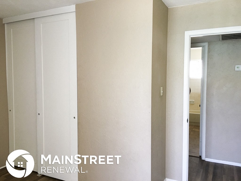 a hallway with white walls and a doorway to a closet