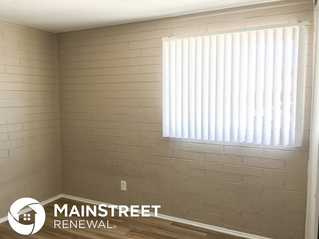 a large window in a small room with white vertical blinds