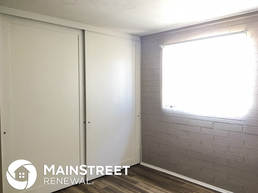 a white walled room with a window and a white door