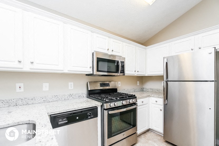 a kitchen with stainless steel appliances and white cabinets