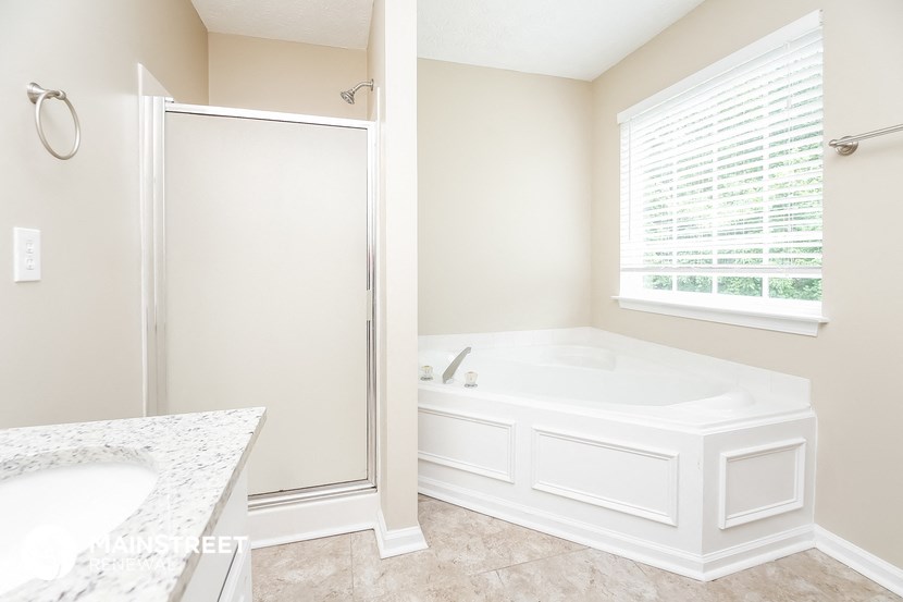 a bathroom with a tub and a shower and a sink