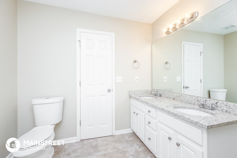 a bathroom with a toilet and a sink and a mirror
