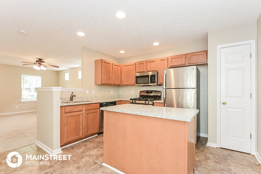 a kitchen with an island and a stainless steel refrigerator