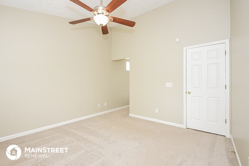 a bedroom with a ceiling fan and a white door