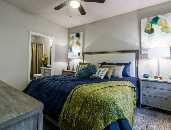 a bedroom with a bed and a ceiling fan