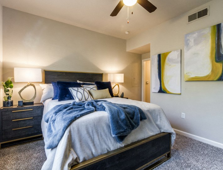 a bedroom with a bed and a ceiling fan