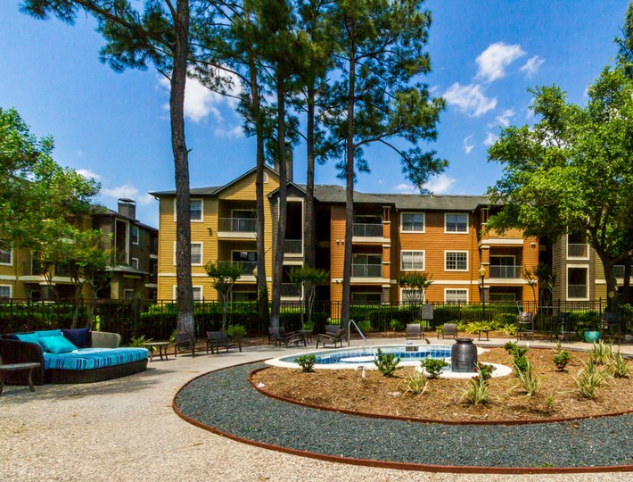 a courtyard with a fountain in front of an apartment building